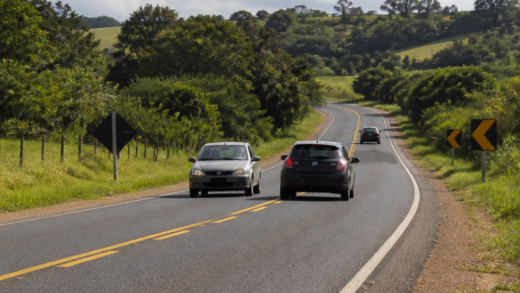 Carro realizando ultrapassagem em rodovia de pista simples enquanto outro veículo se aproxima em sentido contrário, em cena jornalística ilustrativa